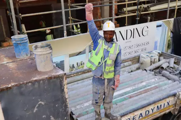 A construction worker salutes the Proteas' passing parade
