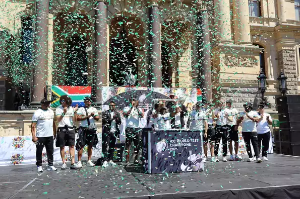 Temba Bavuma hoists the mace high while the confetti falls outside Cape Town City Hall